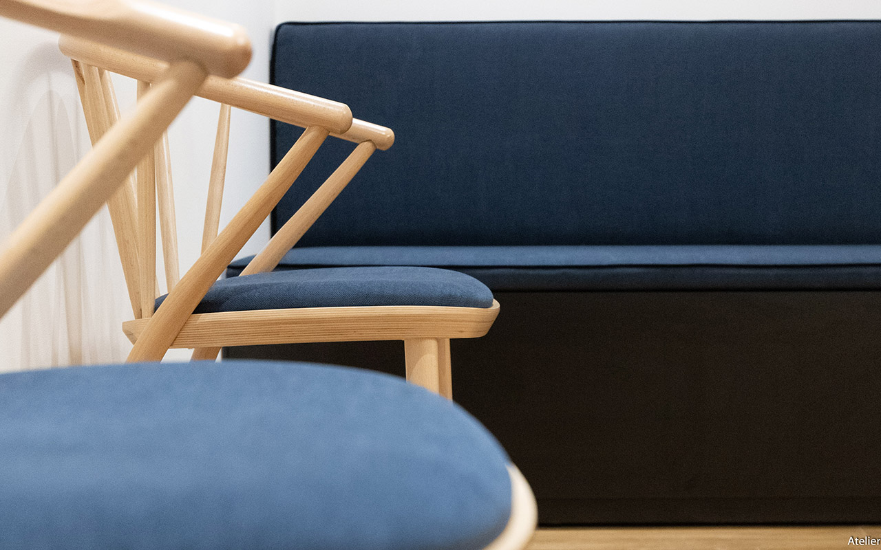 Salle d'attende du cabinet médical avec des fauteuil et canapé bleu marine.