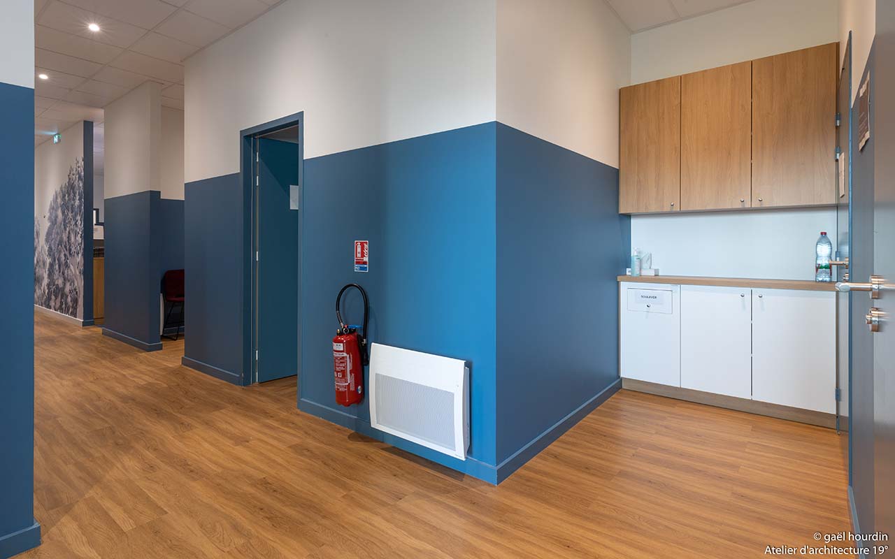 Couloir menant aux différentes salles de soins ainsi qu'un agencement sur-mesure pour créer du rangement.