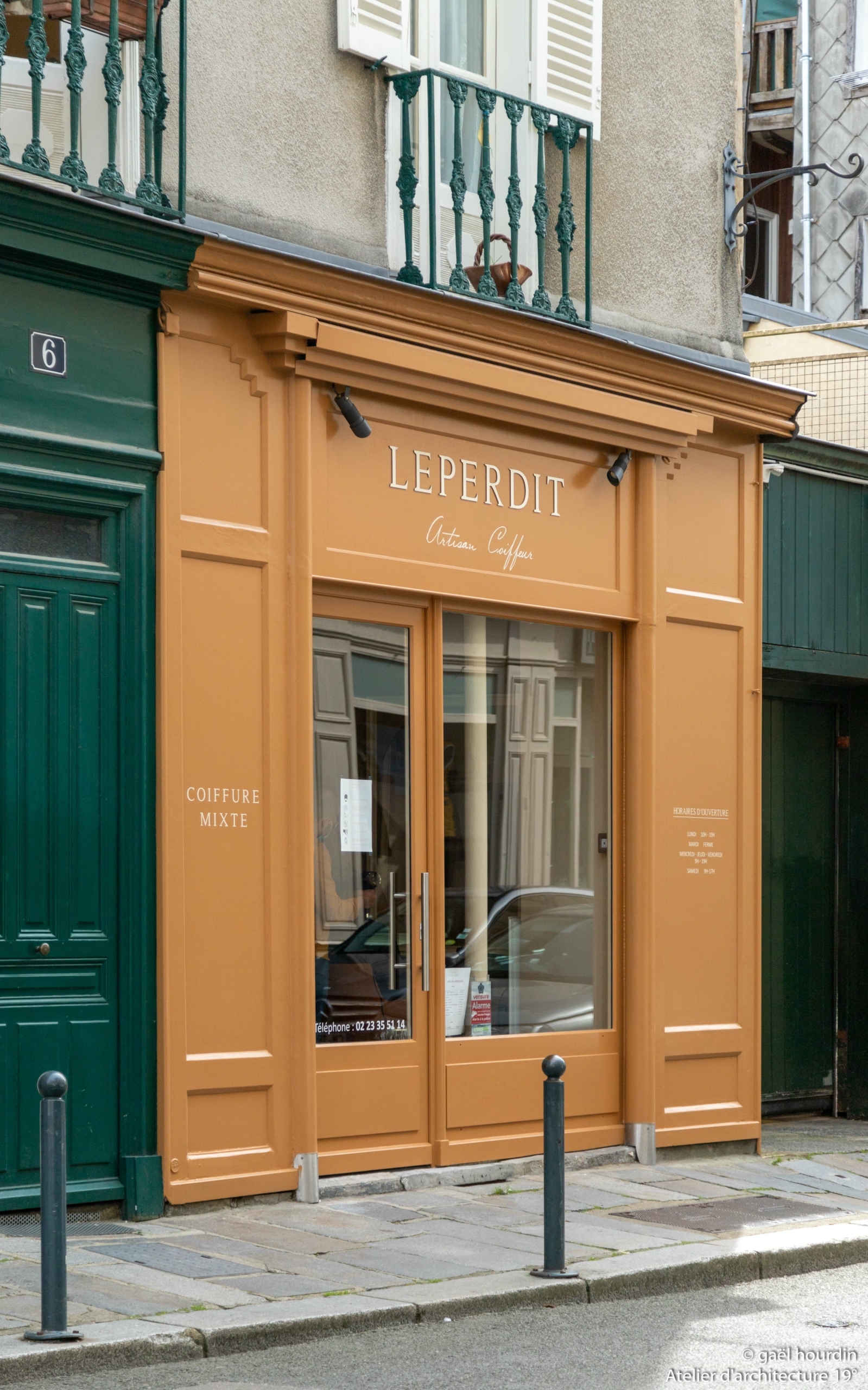 Façade rénovée orange du salon de coiffure.