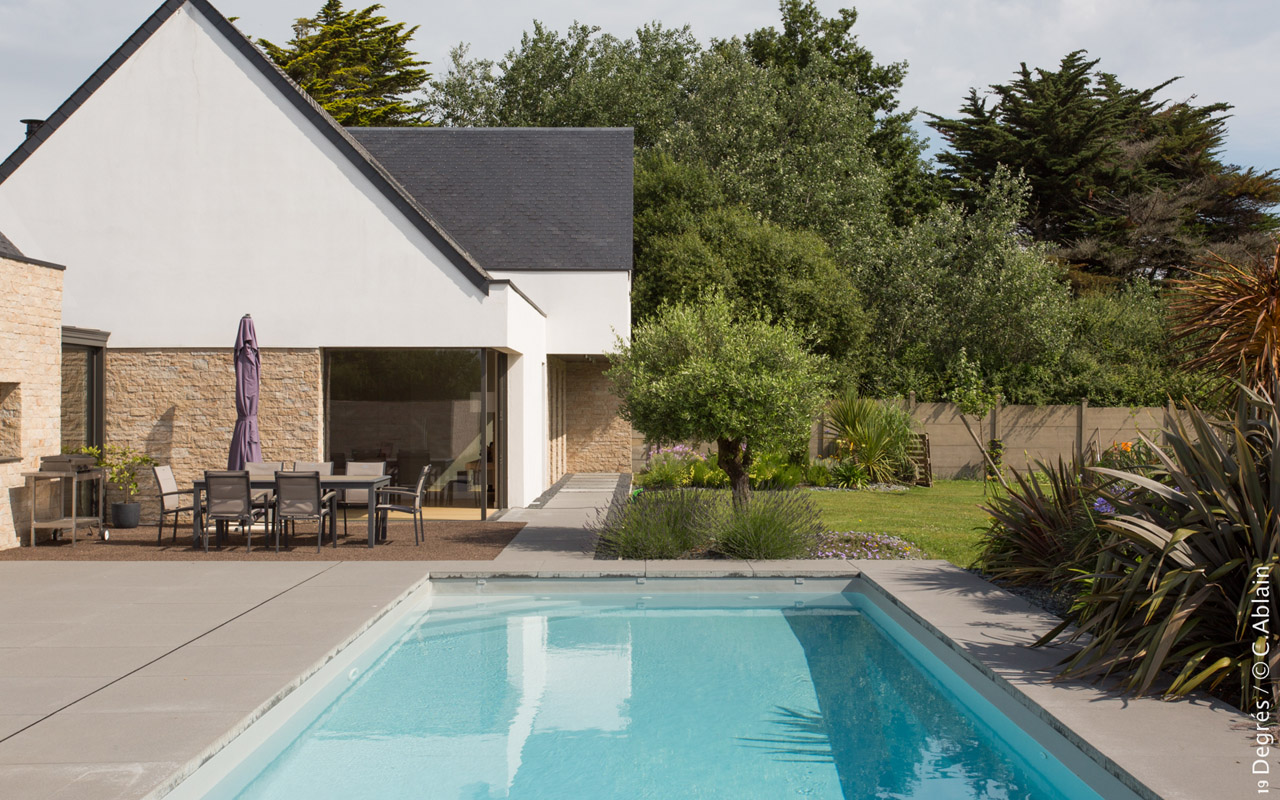 Extérieur de la maison avec salon de jardin, piscine sous-sol et jardin fleurit.