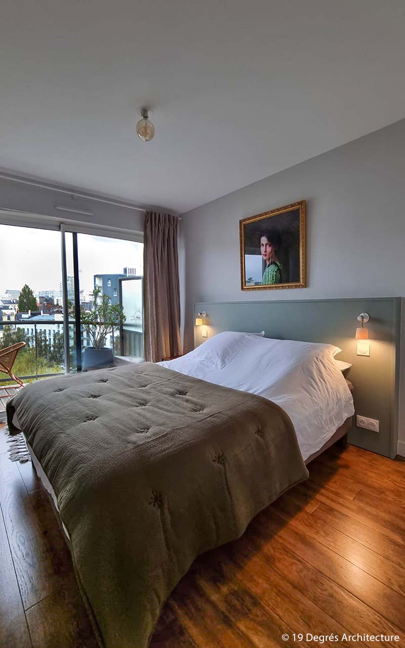 Chambre avec un lit double. Le tout sur les tons vert et blanc. Une tableau d'une femme est au dessus de la tête de lit. La chambre donne sur un petit balcon.