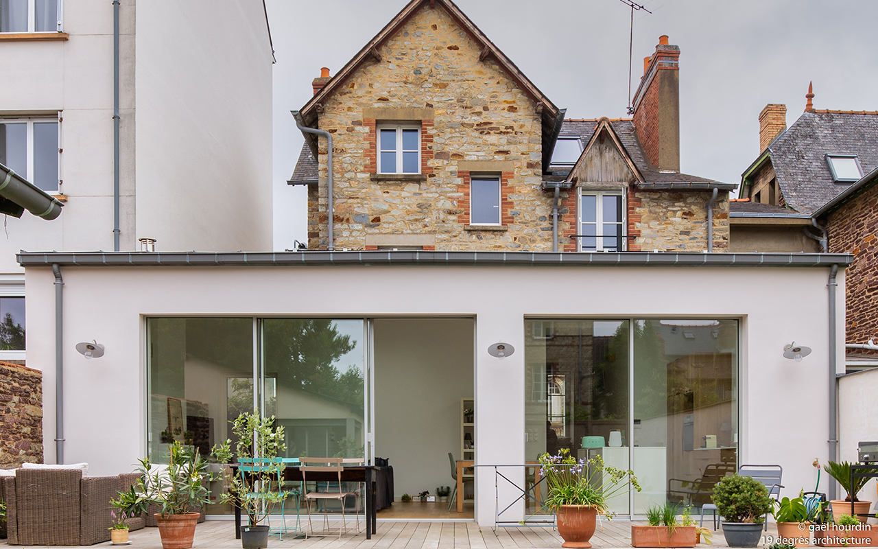 Extension de la maison avec une terrasse fleurie.