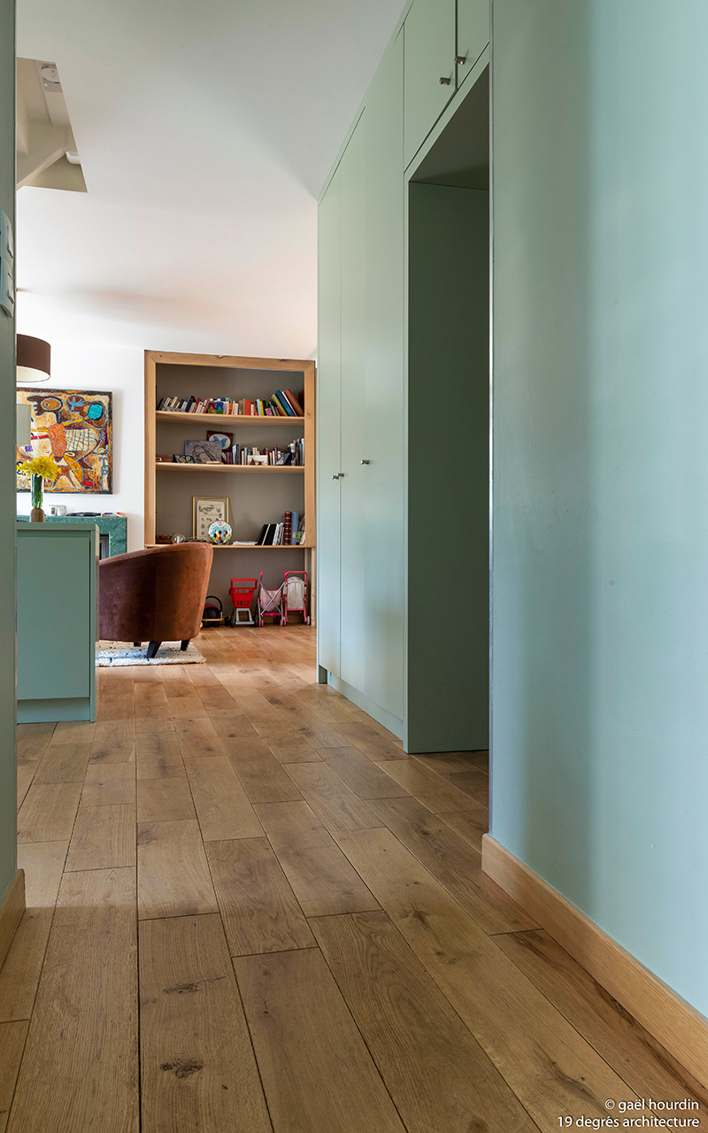 Détail sur le parquet en bois et vue sur le salon.