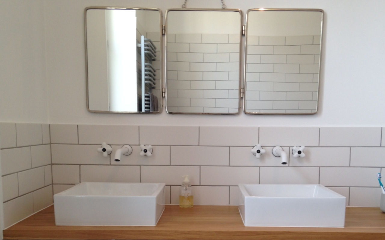 Salle d'eau avec double vasque rectangulaire blanc, et un miroir au dessus.