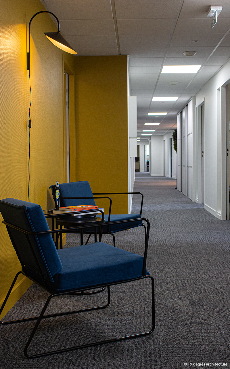 Couloir du cabinet avec deux fauteuils industriels pour faire patienter les clients.