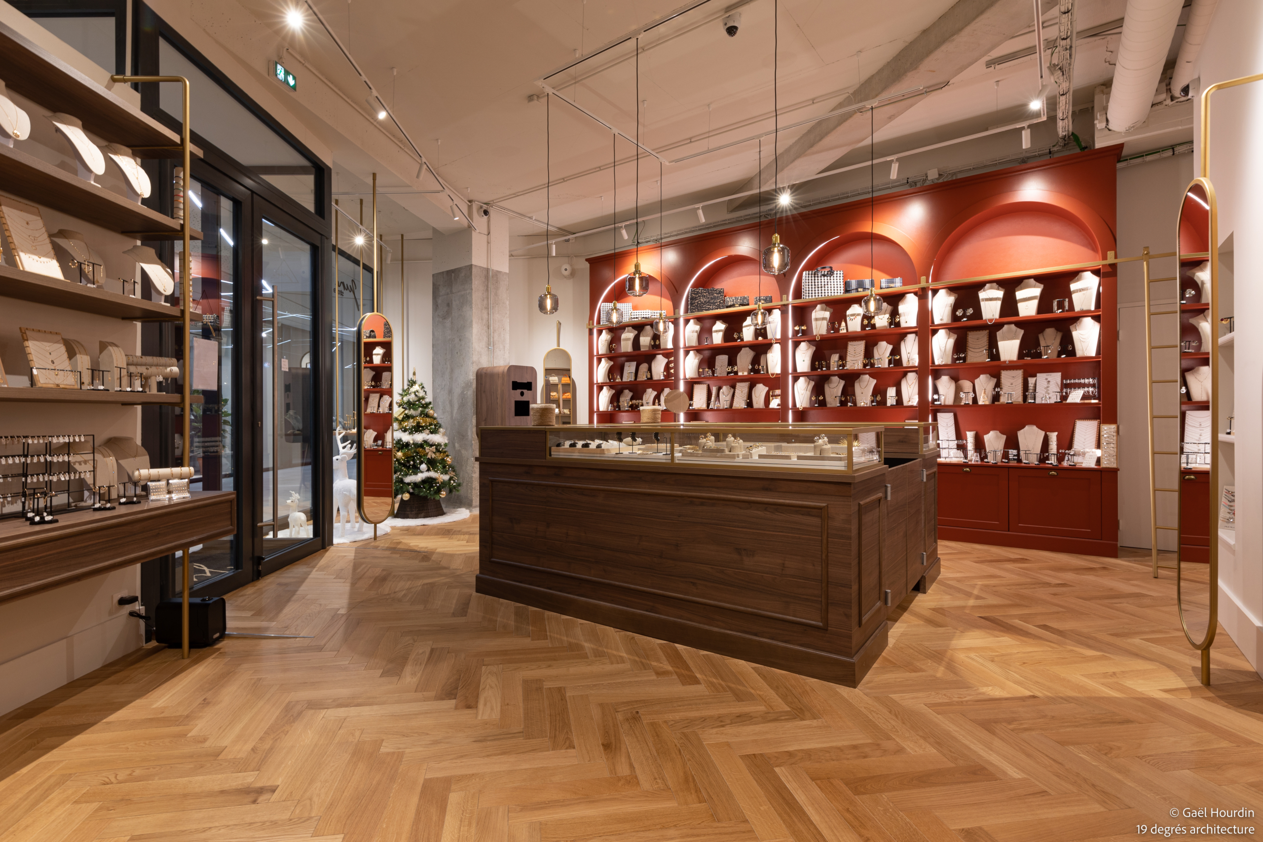 Plan d'ensemble de la boutique avec un ilot central, des étagères à bijoux, luminaires suspendus, devanture de magasin et bibliothèque à bijoux.